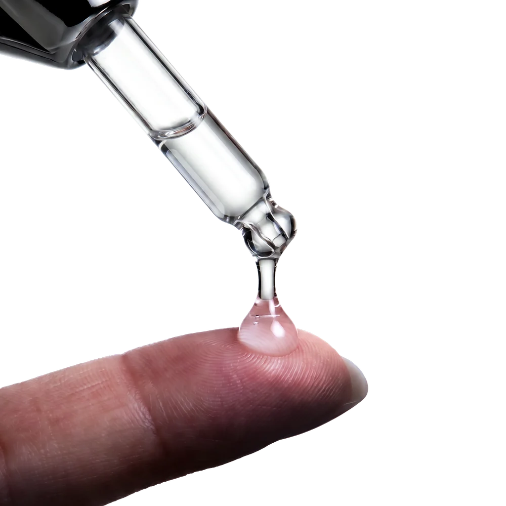 A clear drop of Vexienne® Hair Active X™ serum on a fingertip